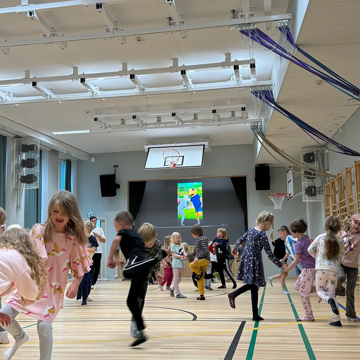 Children moving together during a Geego session in a Finnish school hall
