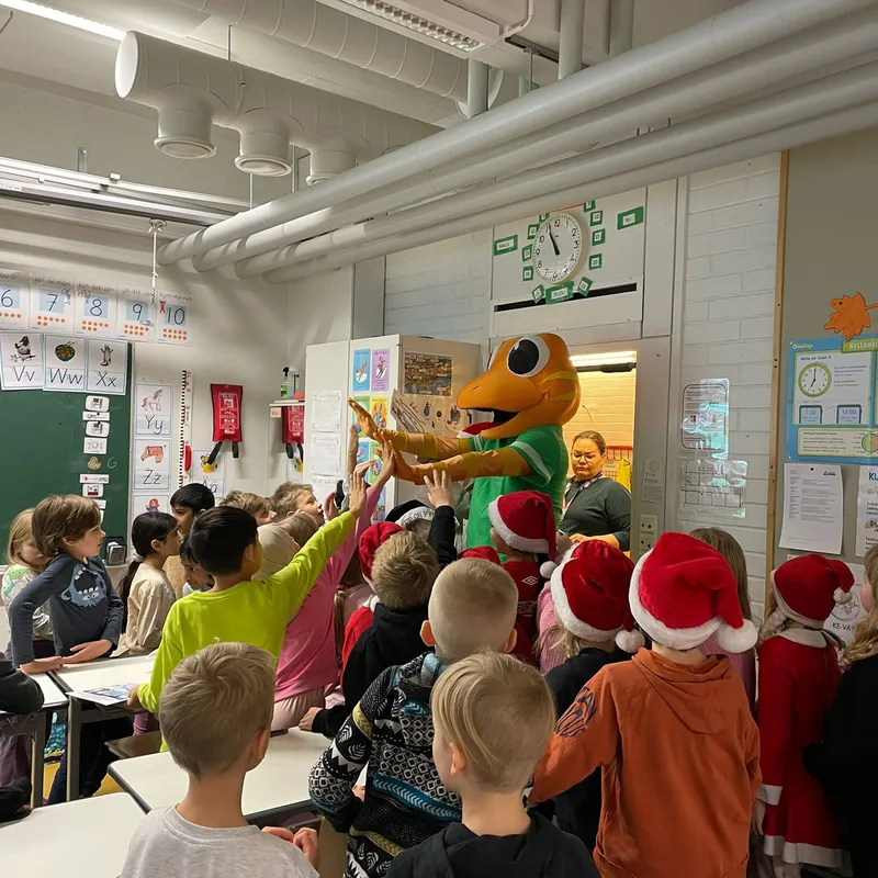 The Geego mascot greeting children at a school